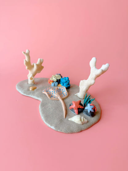 Decorative coral and fish figurines on a pink background