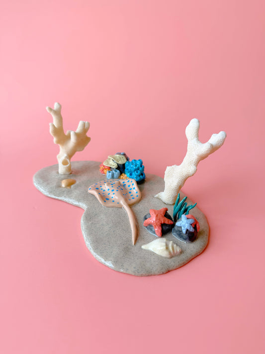 Decorative coral and fish figurines on a pink background